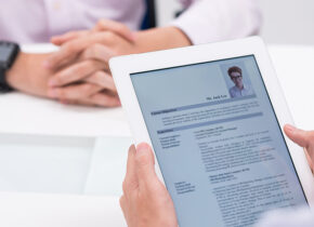 Une personne tient une tablette numérique avec un CV