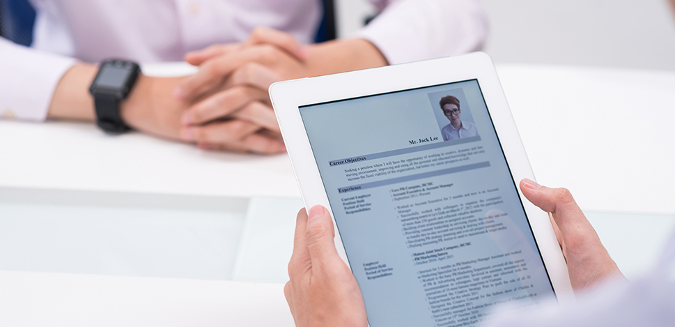 Une personne tient une tablette numérique avec un CV